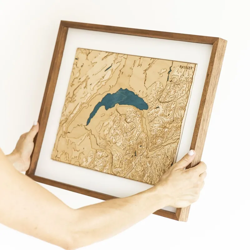 Carte topographique en bois encadrée, tenue à deux mains