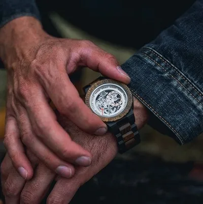 Montre en bois au poignet, cadran squelette
