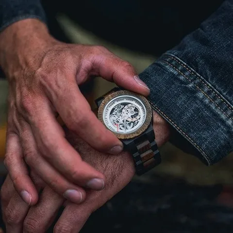 Montre en bois au poignet, cadran squelette