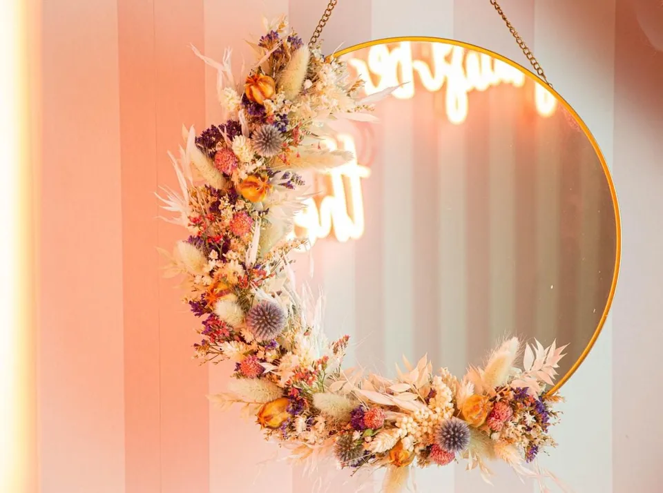 Couronne de fleurs séchées accrochée à un miroir