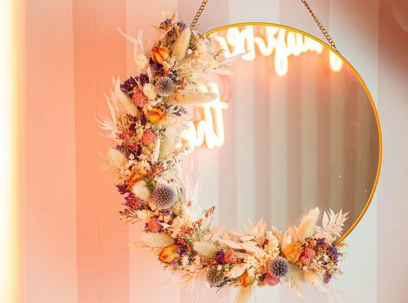 Couronne de fleurs séchées accrochée à un miroir