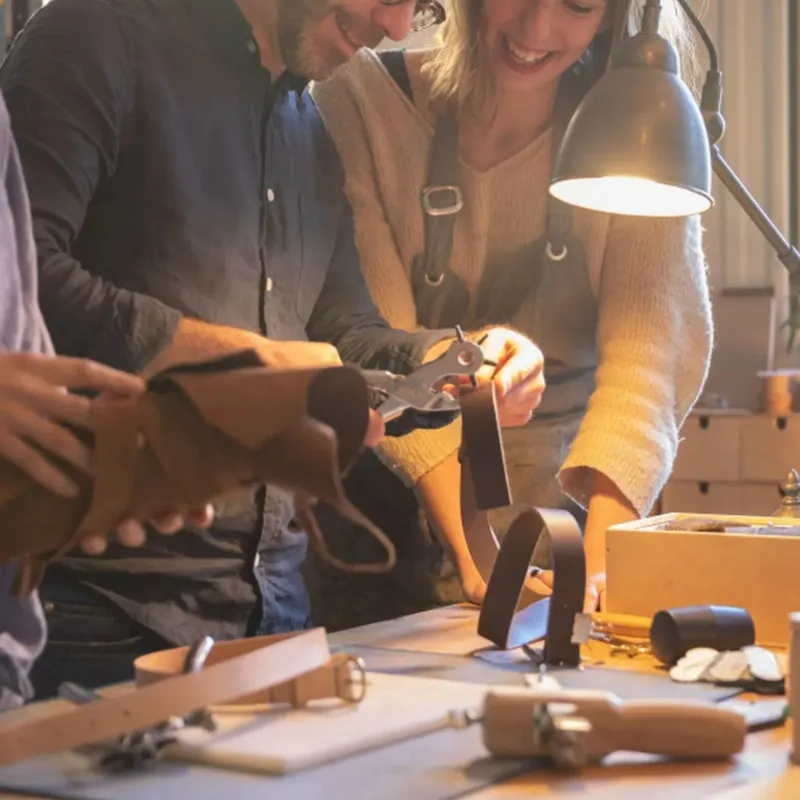Couple qui travaille le cuir à l'établi d'un atelier