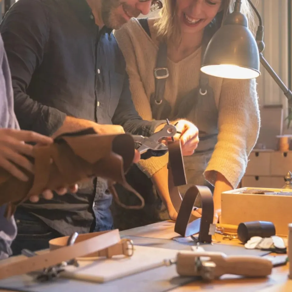 Couple qui travaille le cuir à l'établi d'un atelier