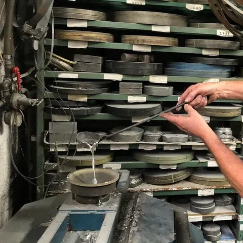 Étain en fusion versé dans un moule d'atelier