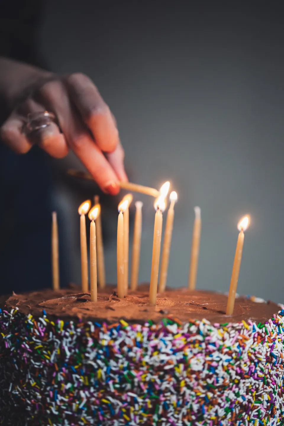 Main allumant des bougies d'anniversaire