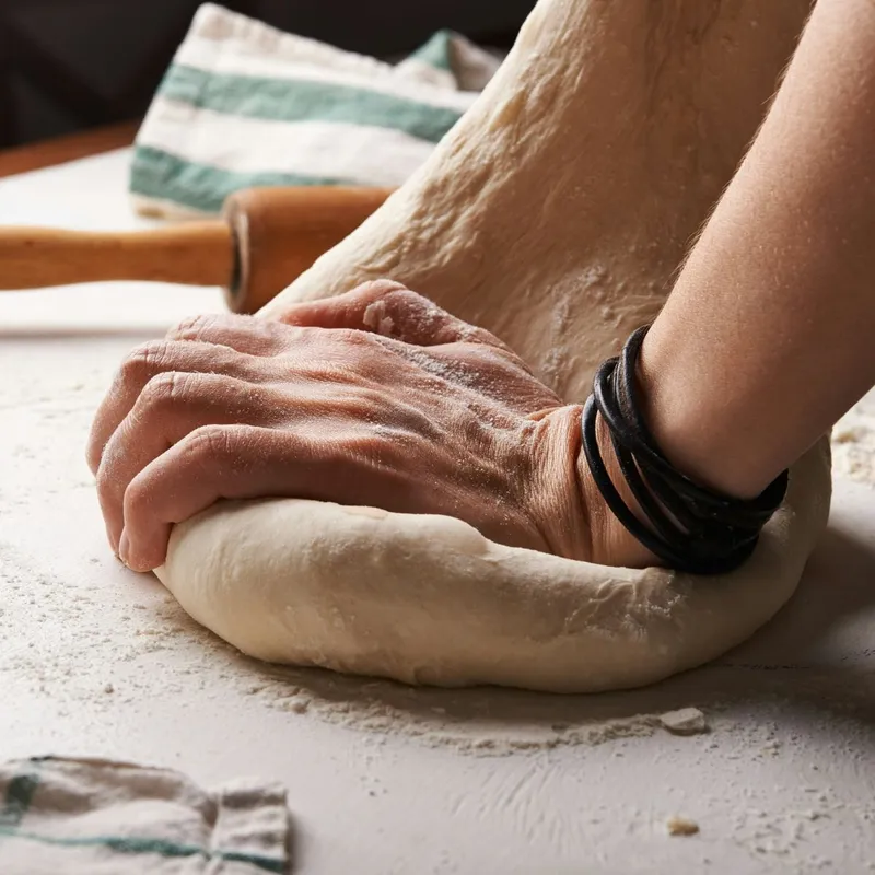 Mains qui pétrissent une pâte à pain
