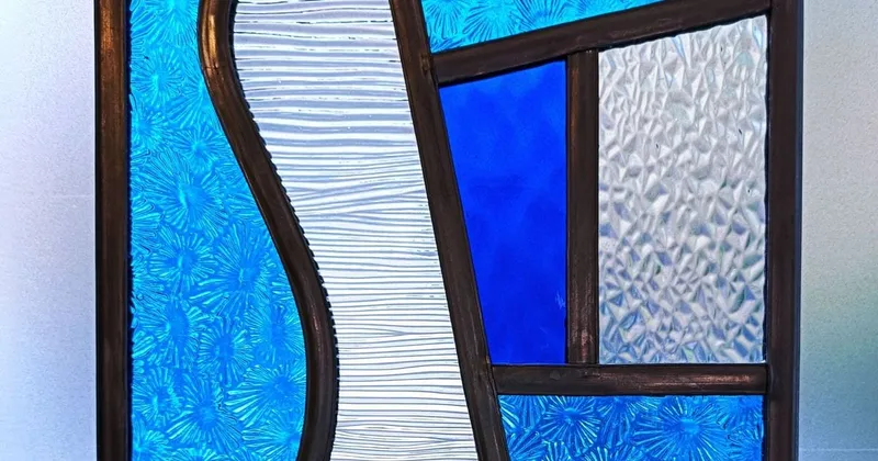 Vitrail aux verres bleus et texturés assemblés par des baguettes de plomb