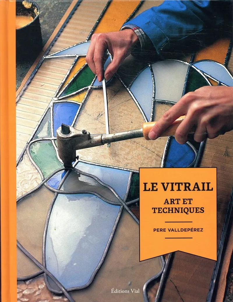 Couverture orange du livre Le vitrail, art et techniques, mains soudant un vitrail