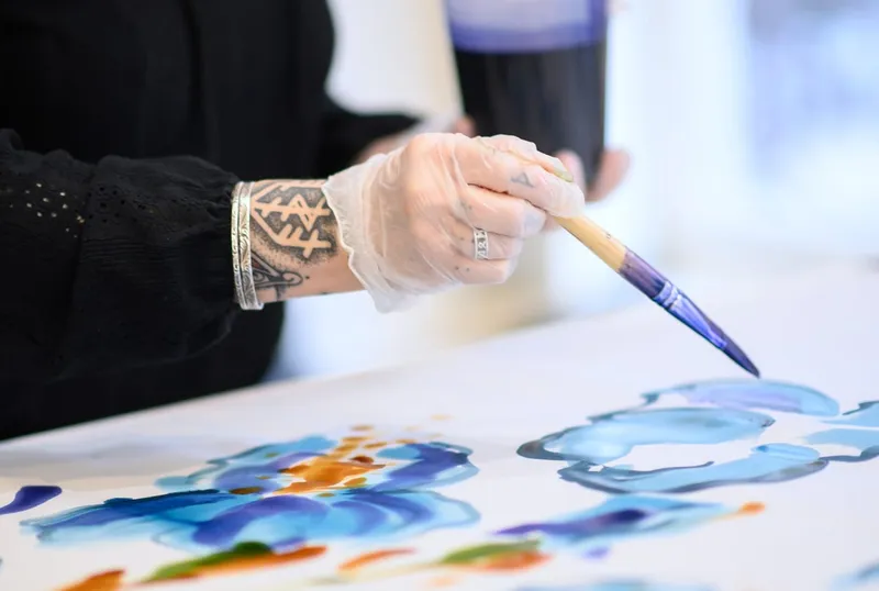 Pinceau posant de la couleur bleue sur une soie tendue